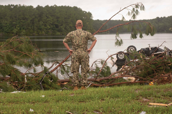 Man in uniform looks at lightning damage