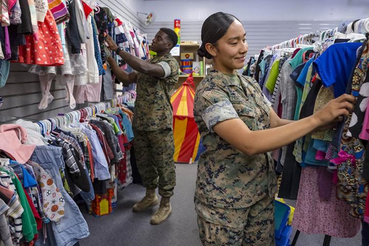 Two military service people shop at a NMCRS Thrift Shop