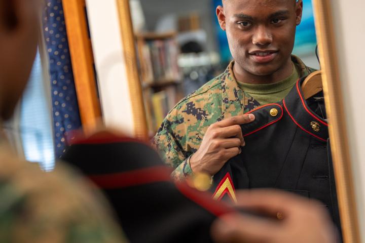 Service member looking at his uniform in the mirror