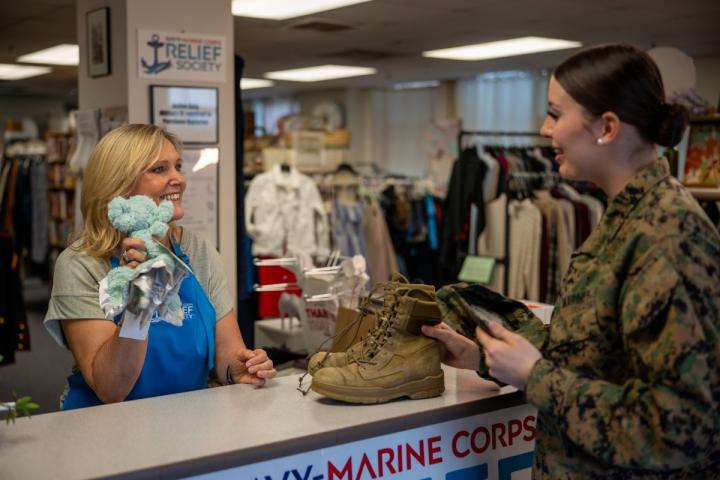 NMCRS thrift shop employee talks with a service member