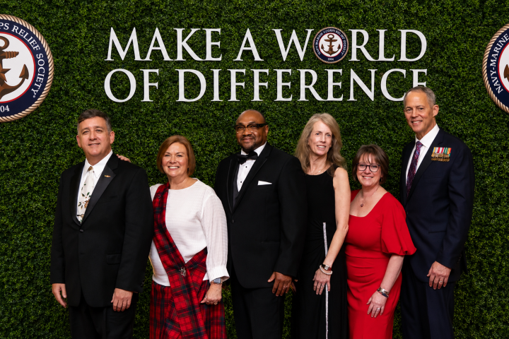 NMCRS senior leadership team at the 2025 NMCRS Ball - beneath a headline that reads "Make a World of Difference." Photo by Jason Dixon Photography