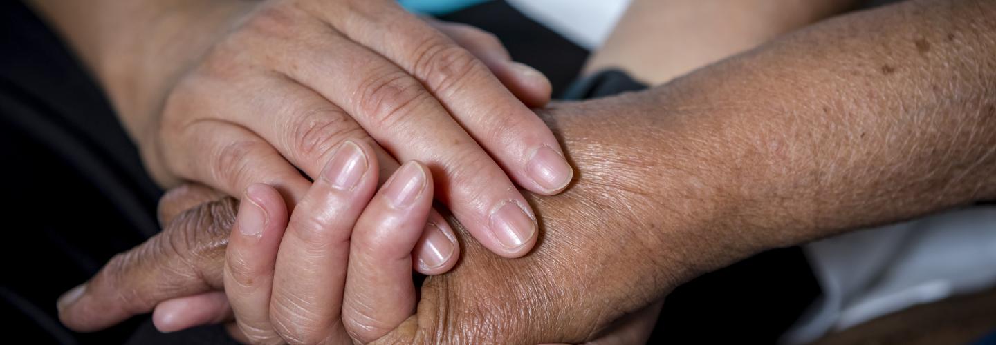 Holding hands with an elderly person
