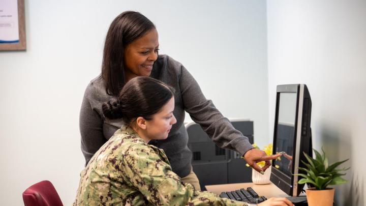 NMCRS volunteer helping a service member with online training