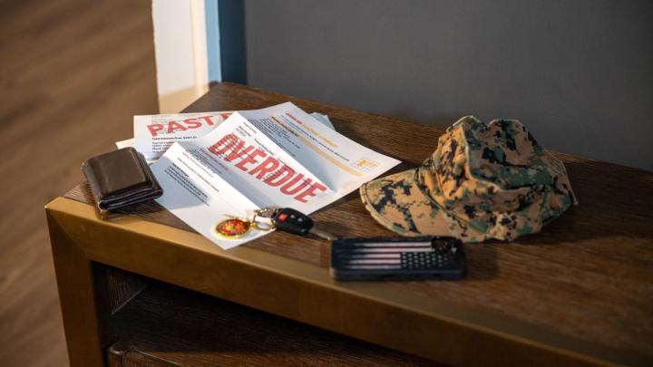 Overdue Bill on Desk with Camouflage Hat