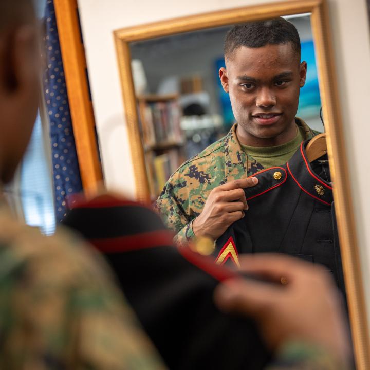 Service member looking at his uniform in the mirror