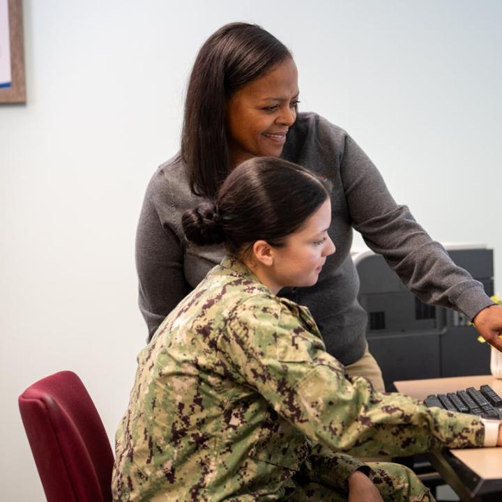 NMCRS volunteer helping a service member with online training